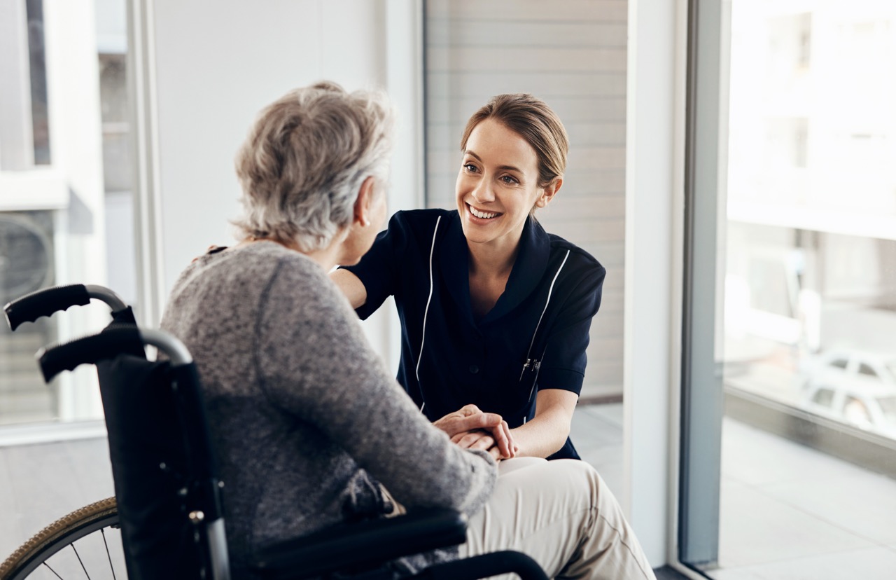 Care professional supporting a service user in a bright care setting